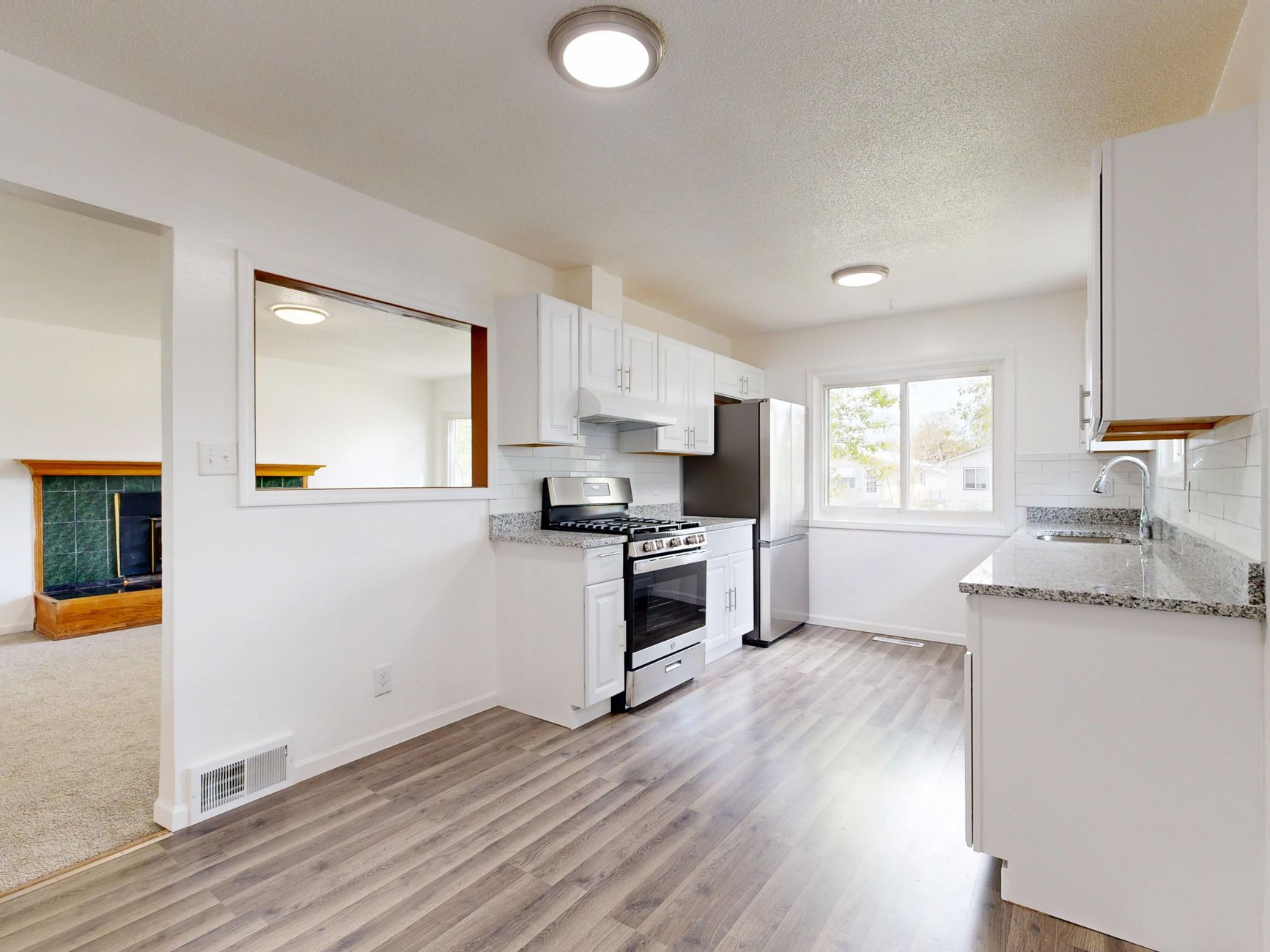 Refinished white kitchen cabinetry with hardwood floors